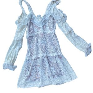 For love and lemons long sleeve white ruffle mini dress with a bow in the back.